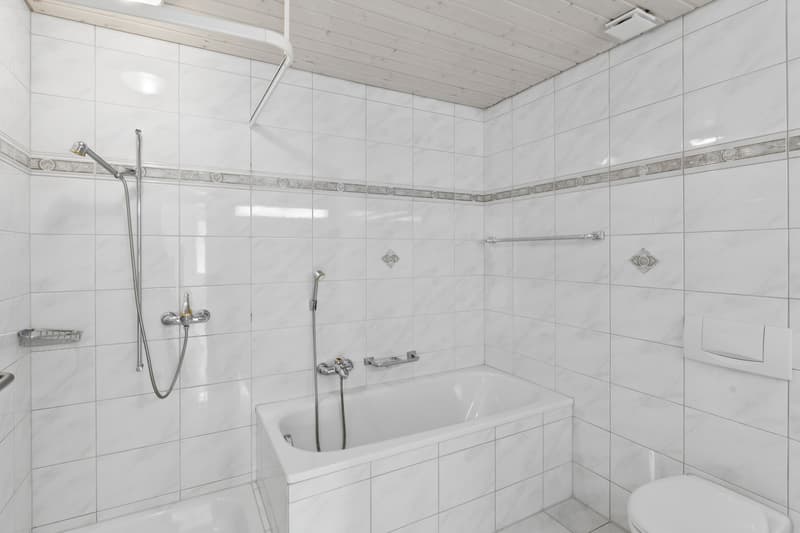 Badezimmer mit Badewanne und Dusche