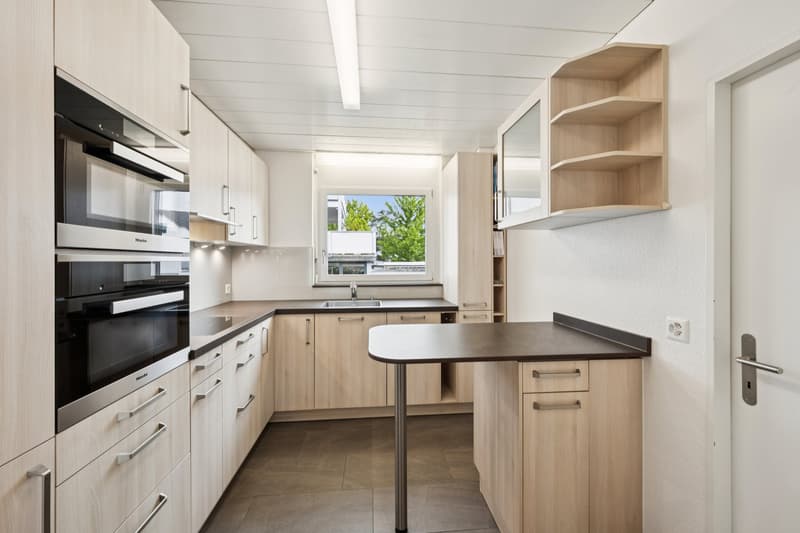 Moderne Küche mit Backofen, Steamer und Induktionskochfeld, viel Stauraum und durchdachten Ablageflächen