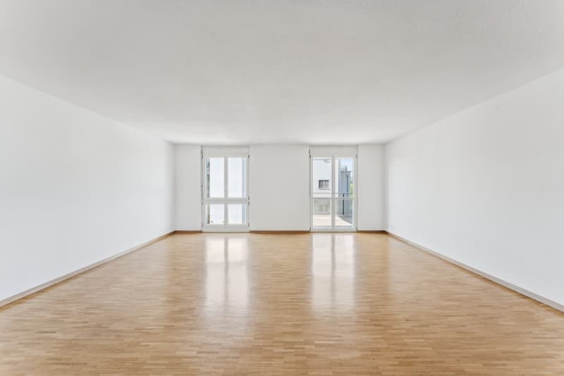 Der helle und offen gestaltete Wohnbereich mit direktem Zugang zum Balkon schafft eine einladende Atmosphäre und erweitert den Wohnraum ins Freie