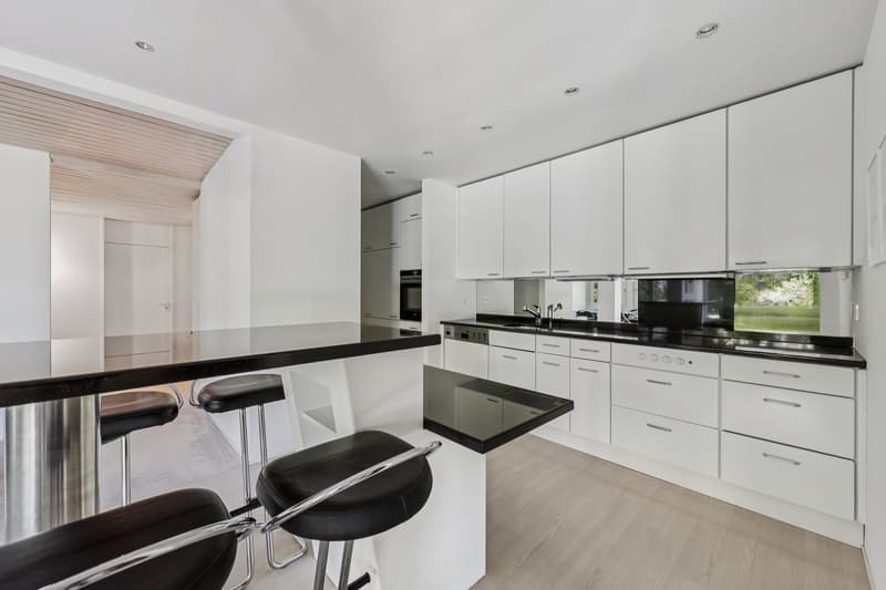 Die schlichte und elegante Küche mit Granitabdeckung ist offen zum Wohn- und Essbereich, mit einem praktischen Hochtisch - ideal für schnellen Kaffe und einen kurzen schwatz