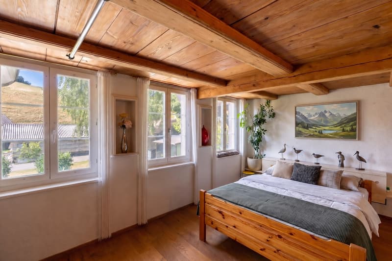 Schlafzimmer mit Sicht auf die idyllische Hügellandschaft rund um Utzigen