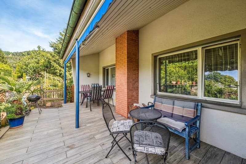 Die grosszügige, halbgedeckte Terrasse mit idyllischem Grünblick erweitert den Wohnraum ins Freie und lädt zu entspannten Stunden in privater Atmosphäre ein