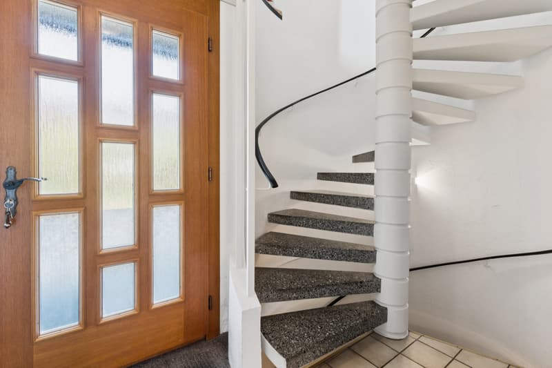 Die elegante Wendeltreppe und der einladende Eingangsbereich verleihen dem Haus einen besonderen Charakter