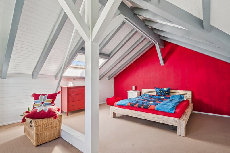 Eines der Zimmer besticht durch charmante Dachschrägen und ein Dachfenster, das für eine helle und freundliche Tageslichtatmosphäre sorgt