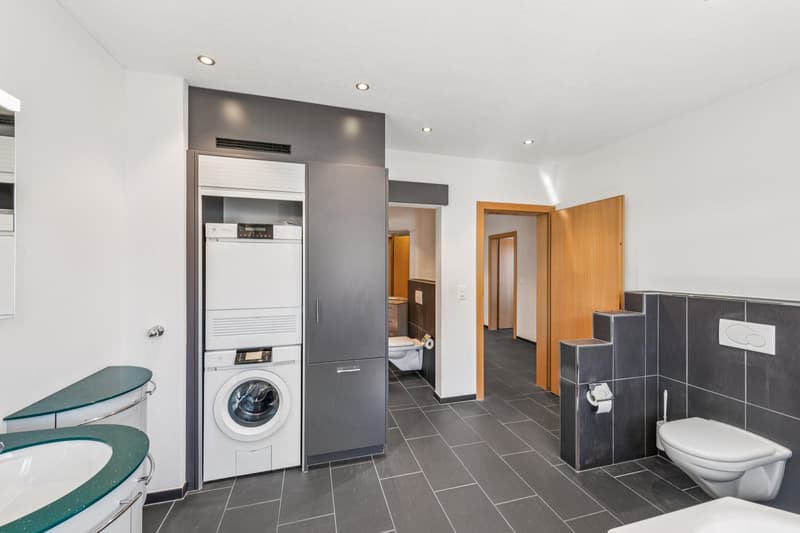 Im Familienbad ist der integrierten Waschturm. Im Hintergrund ist die zweite Nasszelle mit WC und Dusche erkennbar