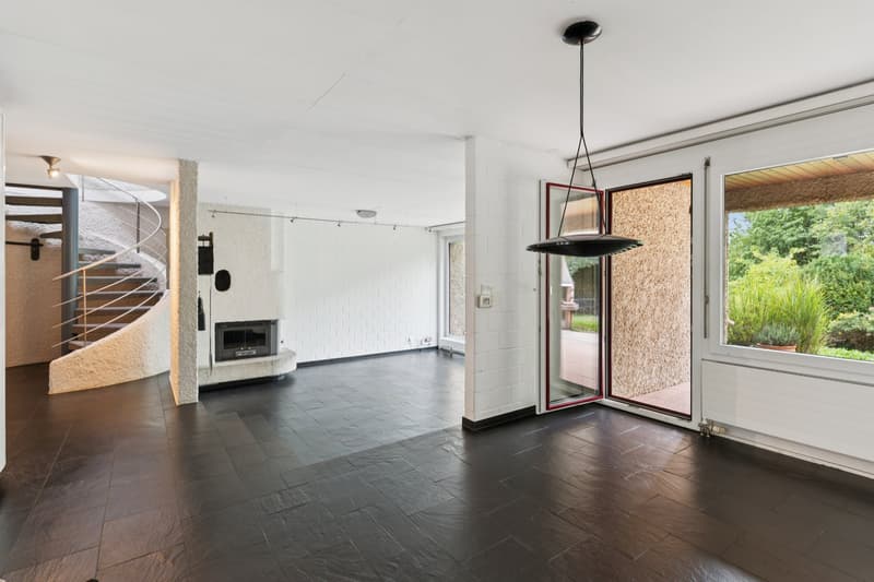 Der Mittelpunkt des Hauses: Grosszügiges Wohnen mit Cheminée, viel Licht und direktem Zugang zum Garten.