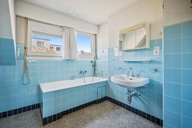 Badezimmer mit Badewanne und angenehmem Tageslichteinfall.
