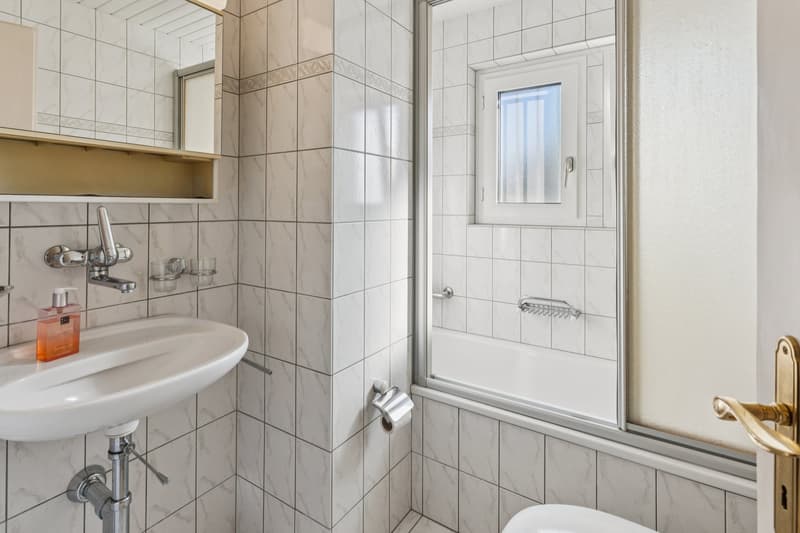 Wohnung EG: Freundliches Badezimmer mit Dusch-Badewanne und angenehmem Tageslichteinfall