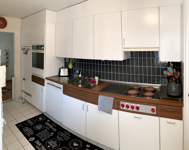 modern kitchen with white cabinets, black tiled floor, stainless steel appliances, gas stove, sink, dishwasher, refrigerator, and a coffee machine