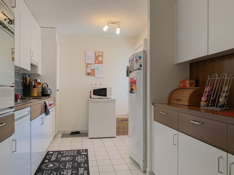 modern kitchen with white cabinets, tiled floor, white appliances, microwave, refrigerator, dishwasher, coffee machine, utensils on the wall