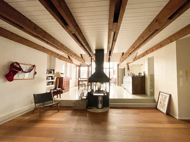 Fireplace, wooden ceiling beams, wooden flooring, armchair, table, cabinet, dining table and chairs, picture frames