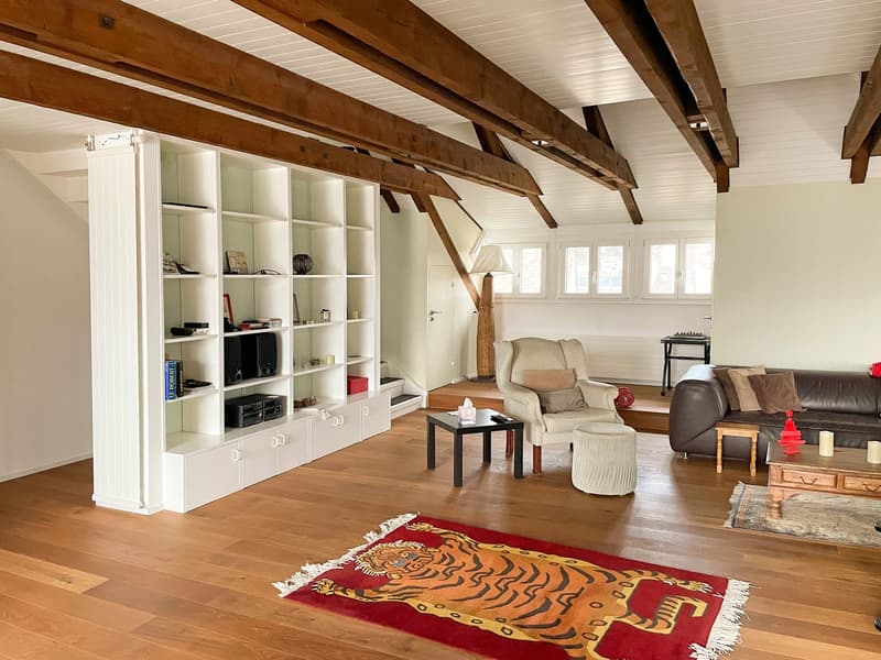 wooden beams, white walls, wooden floor, white built-in shelf, living room with sofa, center table, side table, stool, rug, fireplace