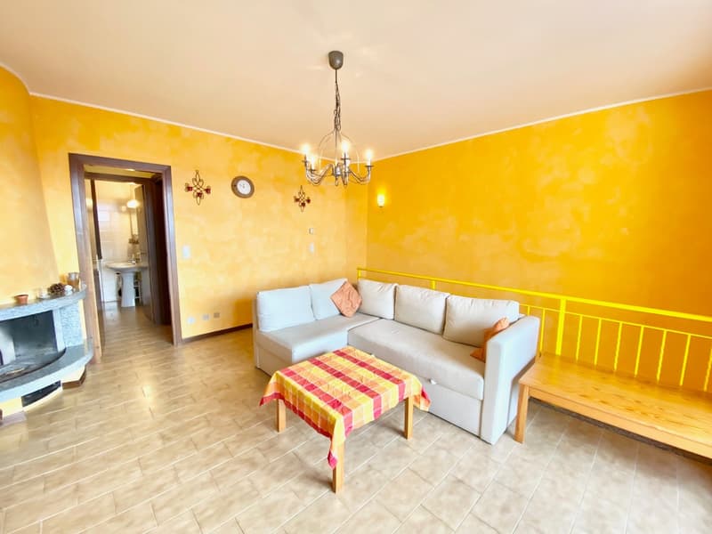 white sofa, fireplace, chandelier, clock, table with a checkered cover