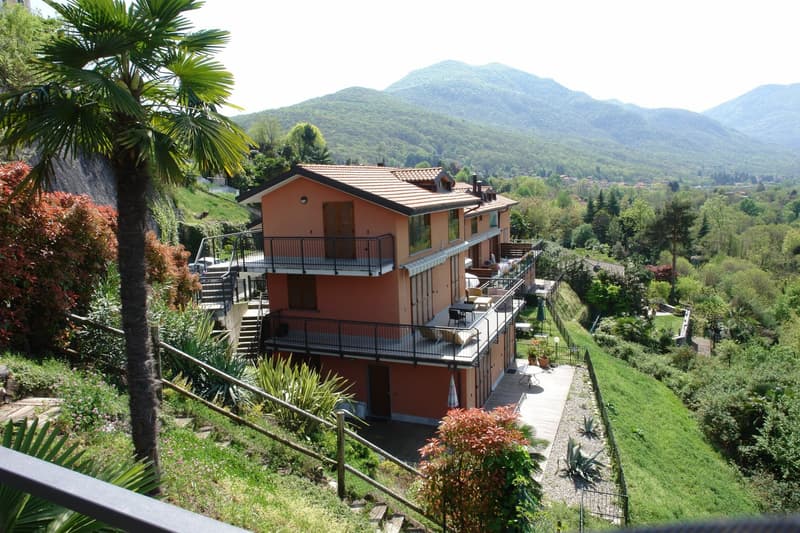 hillside house, 2 levels, brick walls, tiled roof, balconies, garden, panoramic views