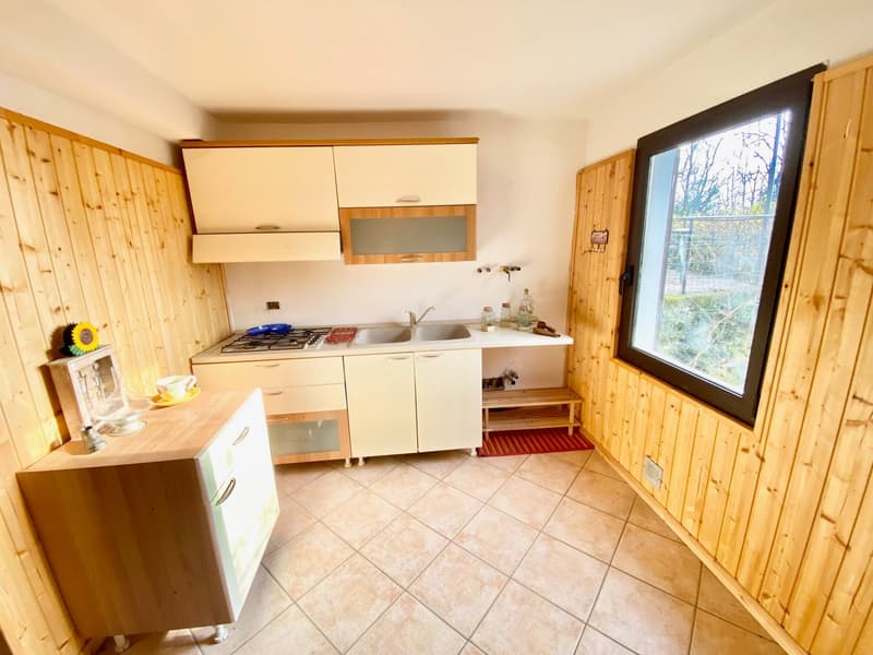 modern kitchen with wooden cabinets, stainless steel sink, gas stove, tiled flooring, large window