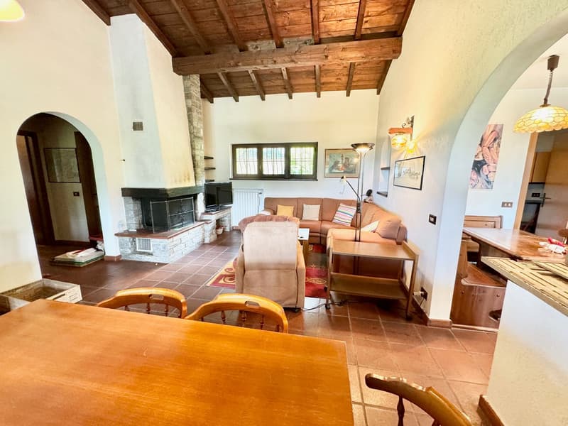 beamed ceiling, fireplace, living room set, couch, coffee table, side table, wooden floor, chair