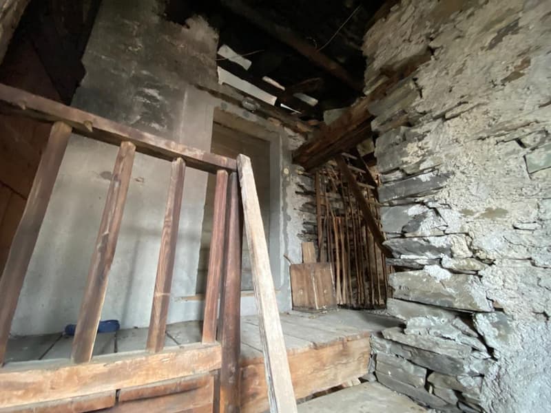 Exposed stone wall, wooden floor, wooden railing, open door