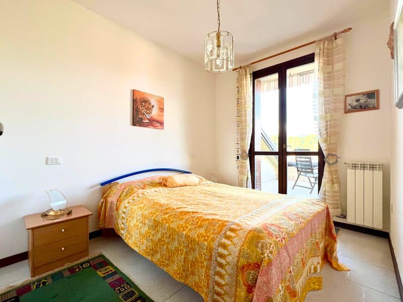 a bed, nightstand, rug, lamp, double doors with glass, balcony, painting