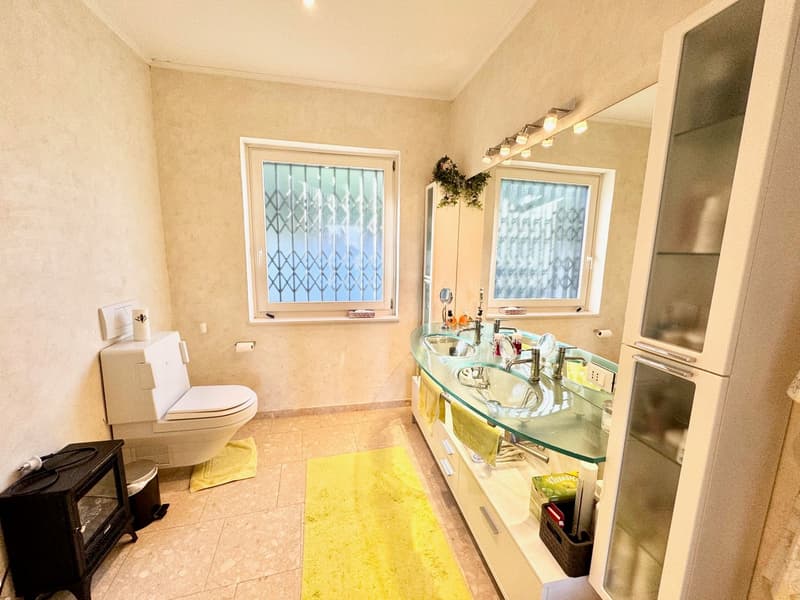 Bathroom with glass vanity, toilet, and washing machine