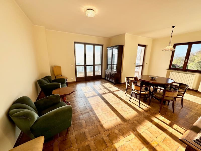 bright room with wooden floor, green chairs, dining table, wooden cabinet, large windows