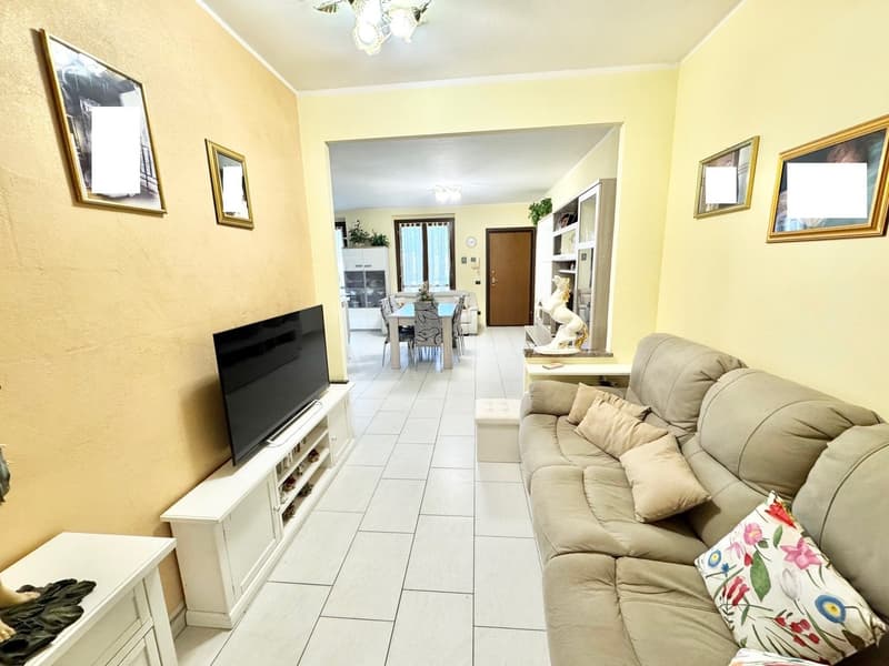 white tiles, couch, large flatscreen TV, television stand, two lamps, framed pictures on wall