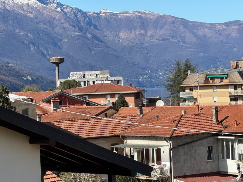 View of the town from a window, houses with terracotta roofs, mountains in the background