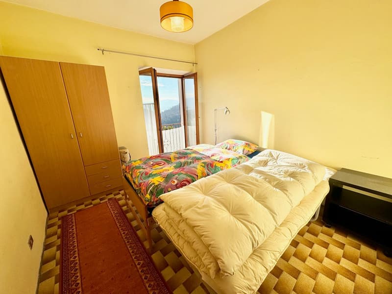 2 single beds, wooden wardrobe, night table, floor lamp, rug, balcony with railing