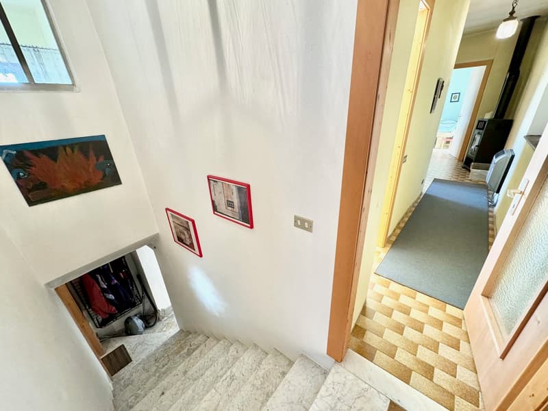 white walls, marble staircase, picture frames, wooden door, checkered flooring