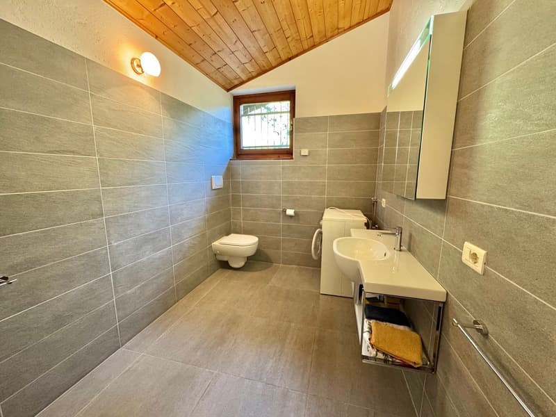 modern bathroom with toilet, sink, and washing machine