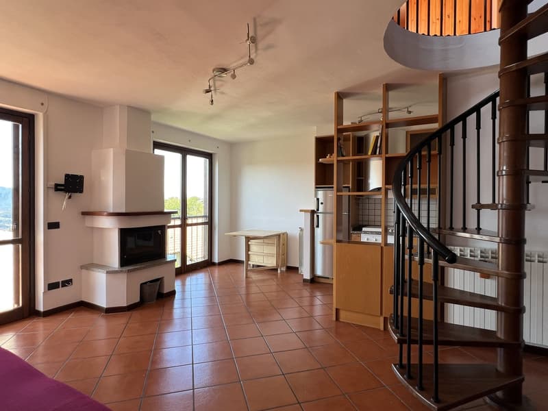 Open-plan living area, Fireplace, brown tiles, wooden table, kitchen, spiral staircase, radiator