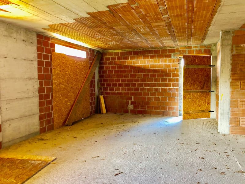 Unfurnished room with brick walls, wooden doors, and a wooden ceiling. Partially covered with plywood.