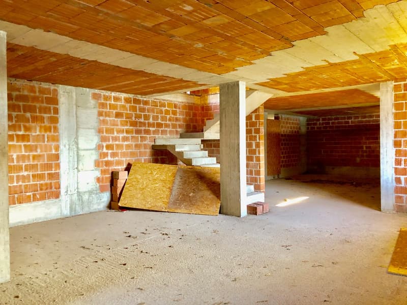 empty room with exposed brick walls, stairs leading up