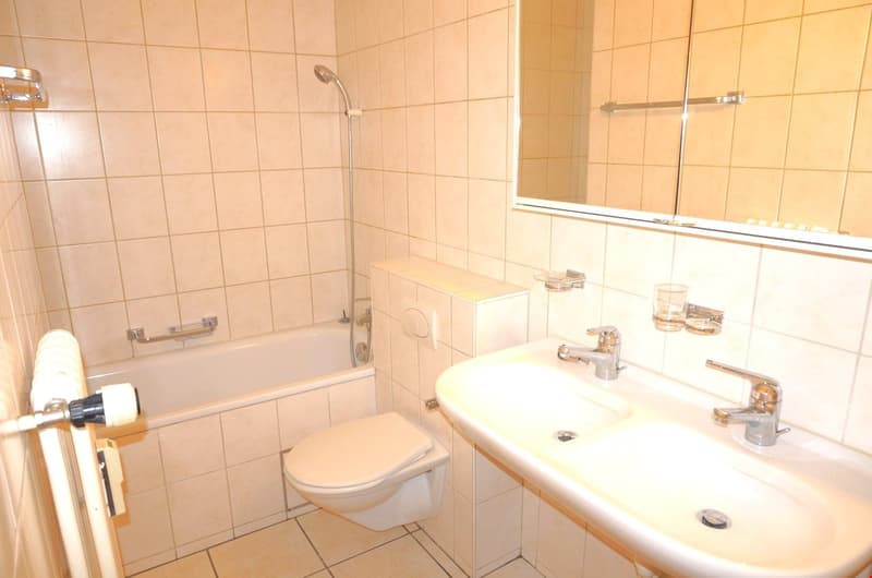Bathroom with bathtub, toilet, sink, mirror, and shower head