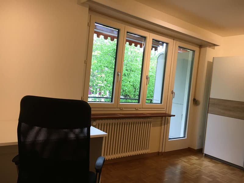 office, black office chair, desk, windows with balcony, radiator