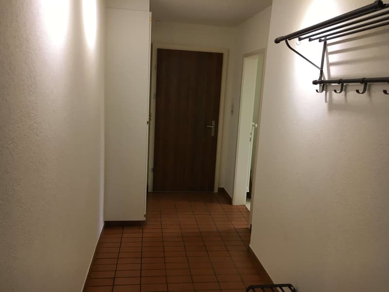 tiled floor, white walls, door, coat rack