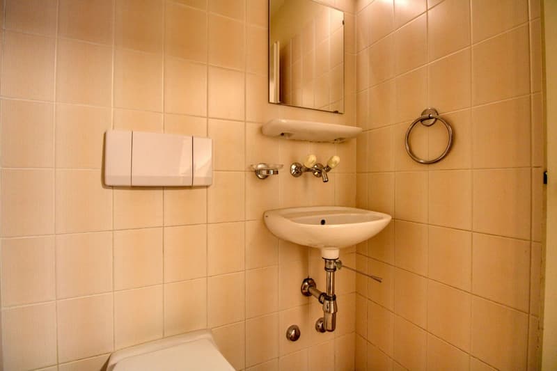 Bathroom, with white sink, mirror, and toilet.