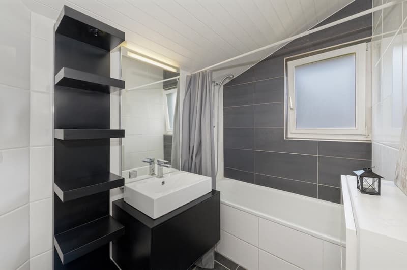modern style bathroom with white bathtub, sink, and shower; tiled walls; shelves