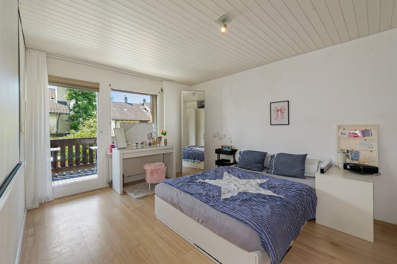 bedroom with wooden floor, double bed, white furniture, balcony, sliding glass doors, balcony with wooden railings