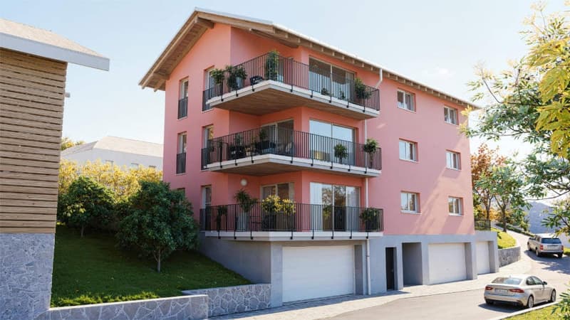 3 story apartment building, pink exterior, balconies, garage, cars parked
