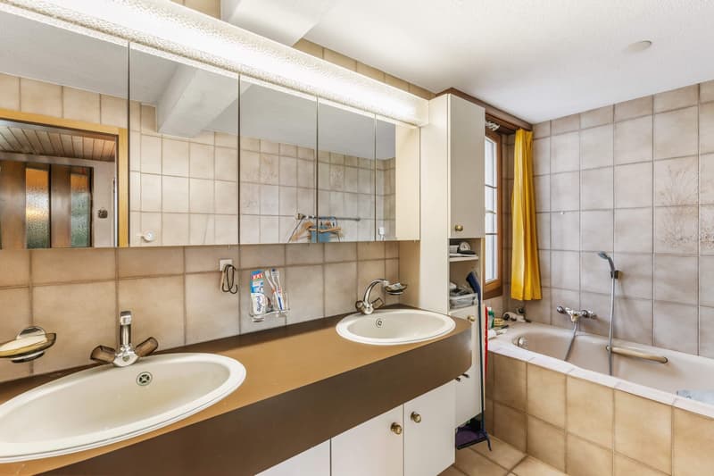 large mirror, two sinks, bathtub, tiled walls and floor