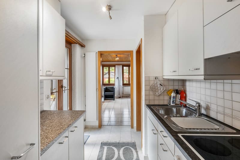 modern kitchen with granite countertops, white cabinets, built-in appliances, tiled floor