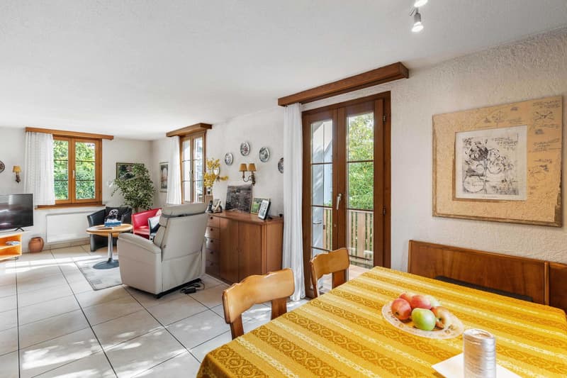 Balcony, living room with white tiled floor, white leather armchair, TV, wooden cabinet, dining table with yellow tablecloth, wooden chairs