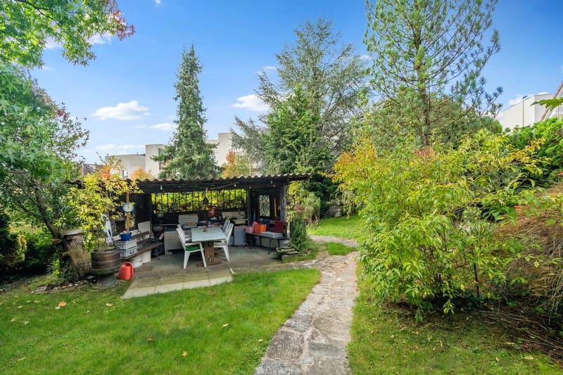 garden with grass, trees, shed, garden tables, barrels, walking path