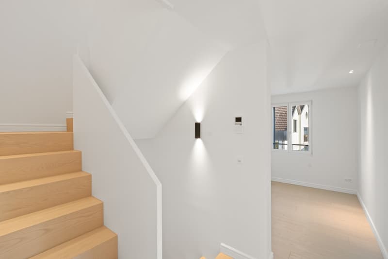 white walls, wooden stairs, white ceiling, wall mounted light, window