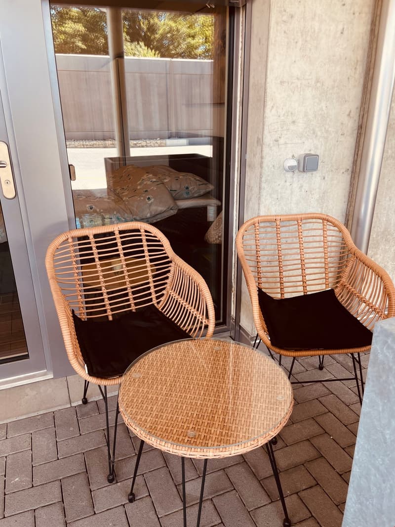 balcony with wicker furniture and a table, sliding glass door, and a view of the outside