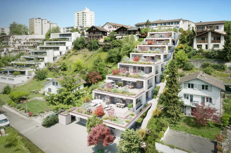 Multiple story building complex with terraced gardens on each floor, balconies, garage, surrounding trees, plants