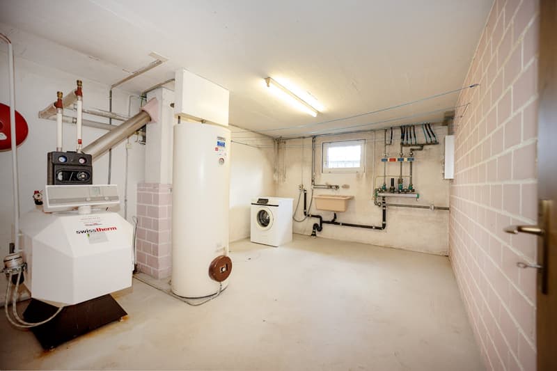 laundry room with washing machine, water heater, pipes, and a sink