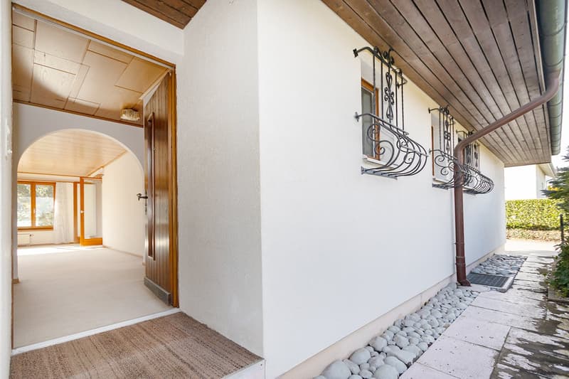 white house, wooden door, arch entrance, white floor, small garden, balcony