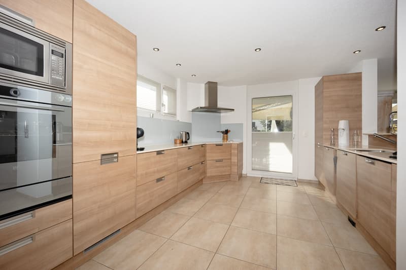 modern cabinets, tiled flooring, microwave, oven, stovetop, sink, stainless steel appliances, glass windows, door