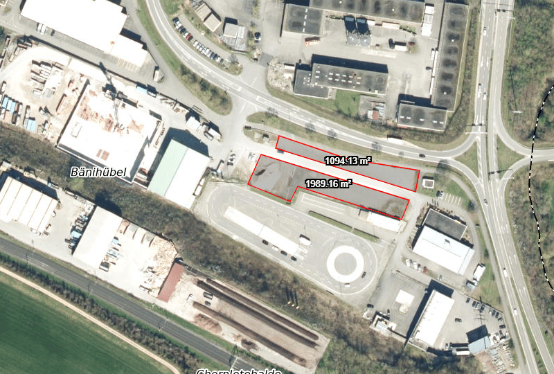 Two adjacent lots, one measuring 1094.13 sqm and the other 1989.16 sqm, both situated in a commercial area near Banhübel and Chernletchalde, with surrounding buildings and parking spaces.